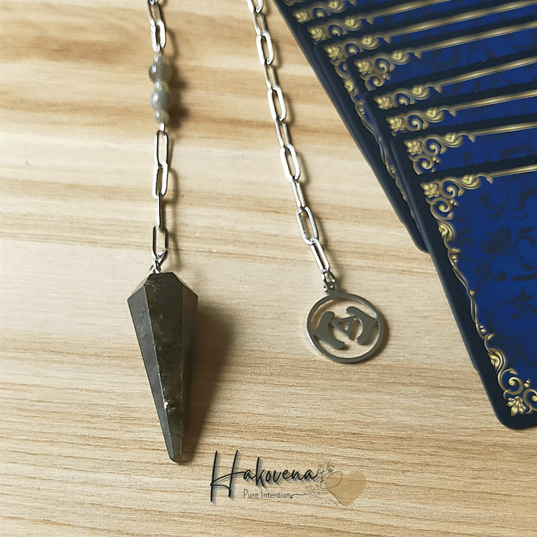 Pendule en Pendule divinatoire en Labradorite – Protection & Clairvoyance – avec des cartes sur un coin.